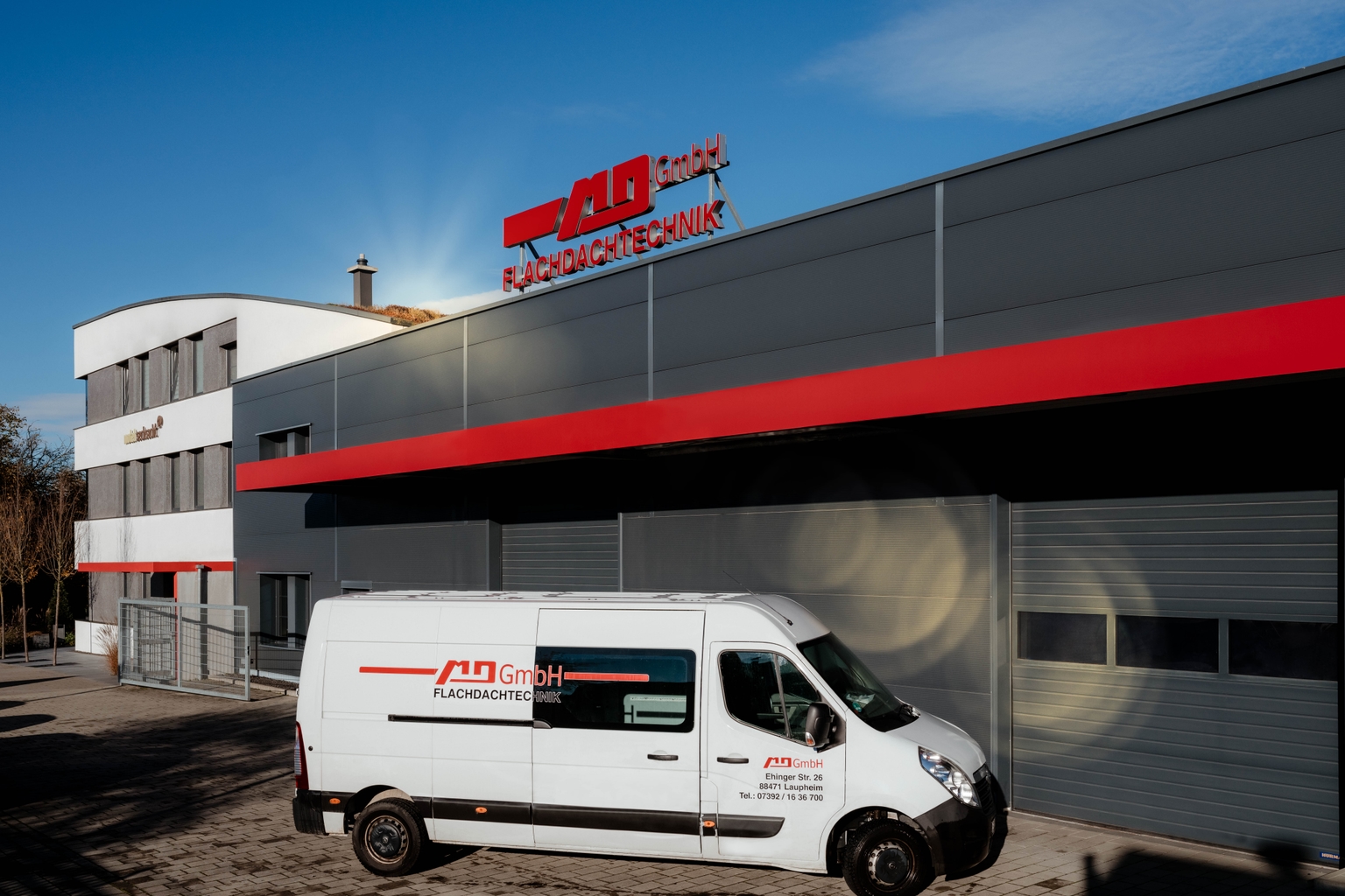 Das Firmengebäude mit einem Dienstfahrzeug