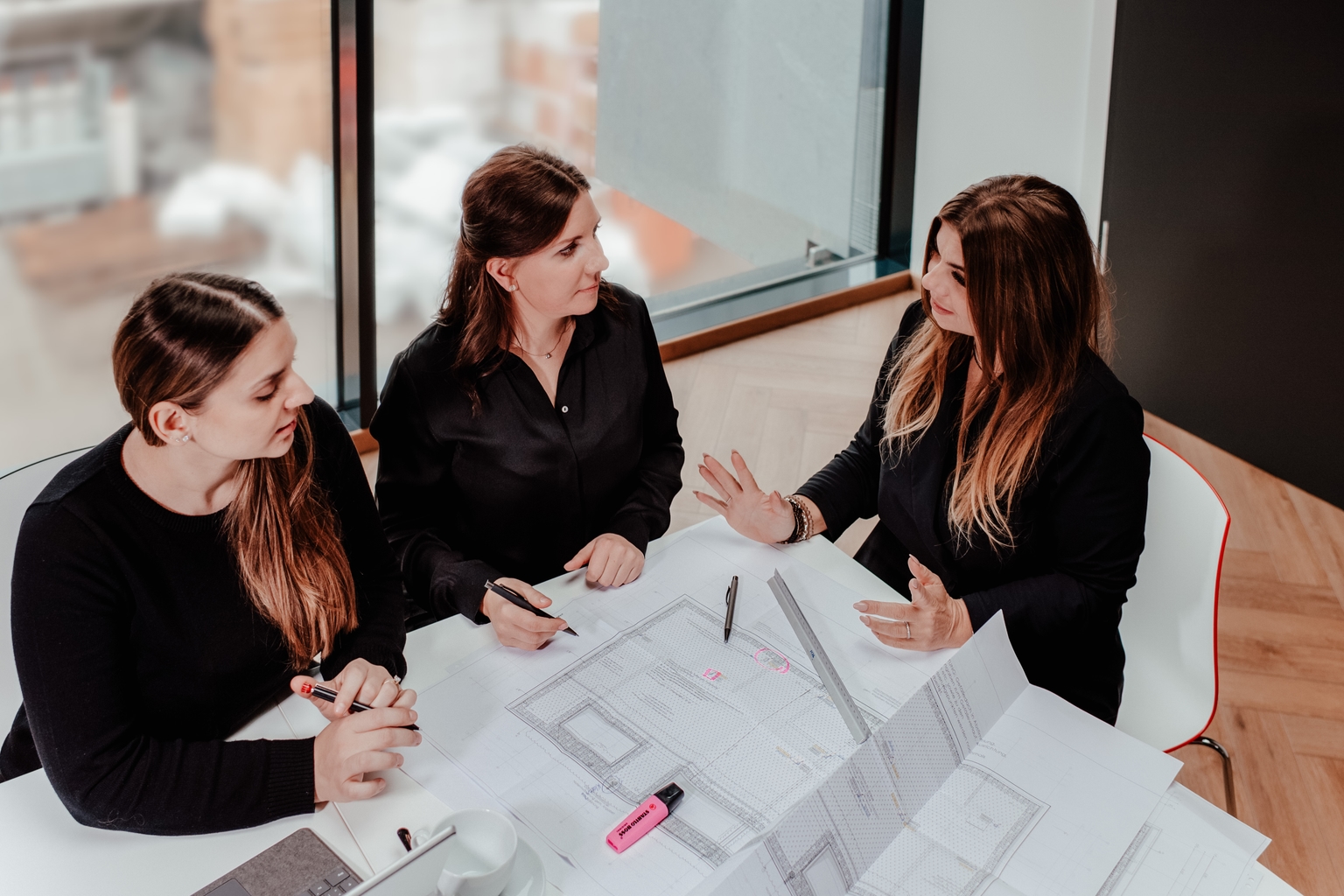 Drei Damen diskutieren eine technische Zeichnung