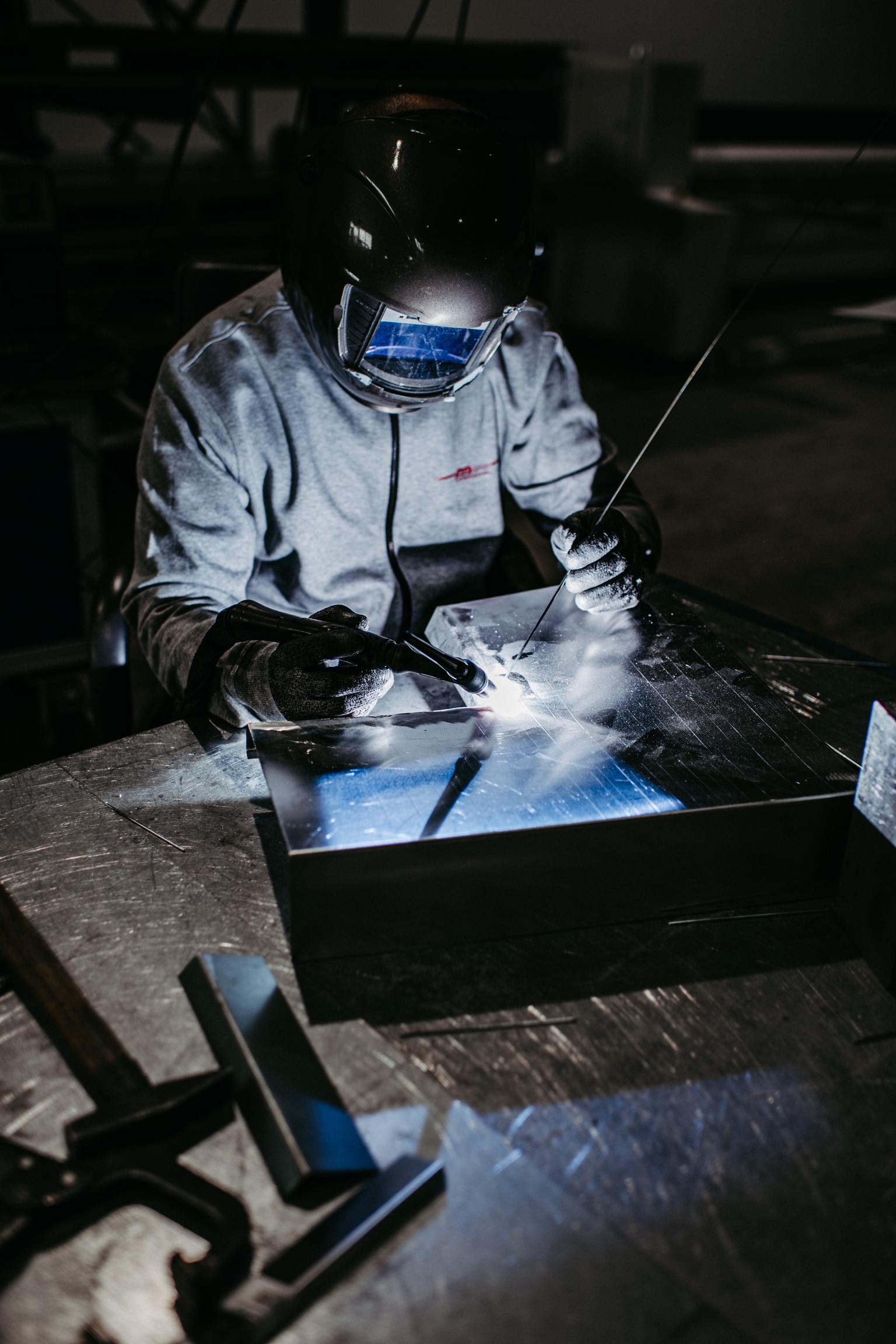 Ein Schweißer der zwei Metallteile verbindet